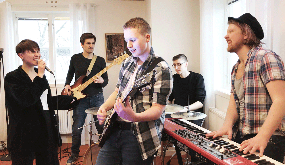 En popensemble med sång, elbas, elgitarr, trummor och keyboard spelar popmusik tillsammans
